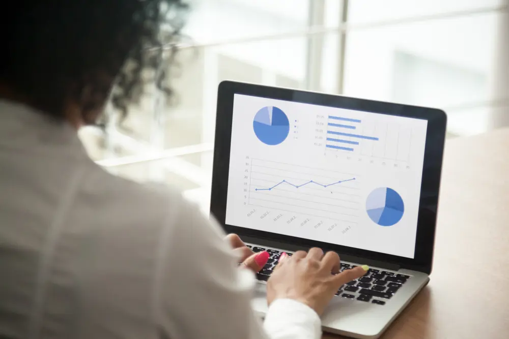 African project manager using computer software analyzing financial market rates